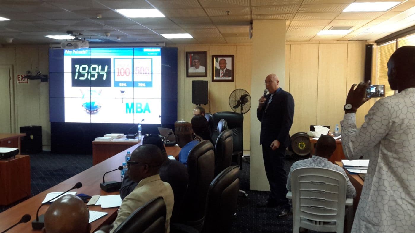 Presenter beside a screen showing a “1984” slide as a delegate takes a photo