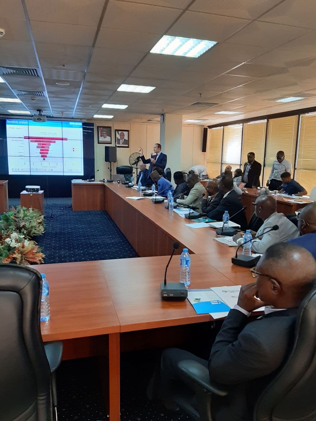 Delegates facing a screen showing a risk chart