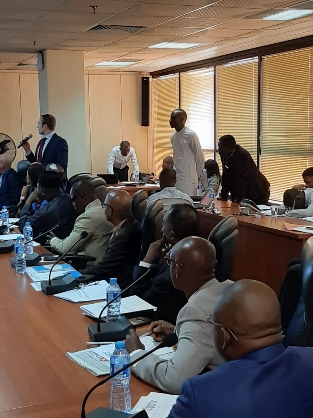 Delegates at the table with a presenter at the far end